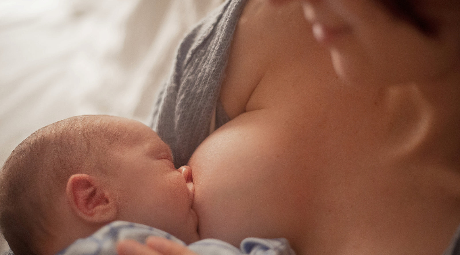 Foto de Breastfeeding baby close up. Pretty mother holding her